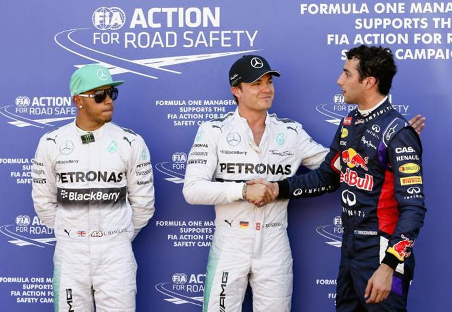 Stretta di mano fra il poleman Rosberg e Ricciardo dopo la pole. Hamiton osserva perplesso. Epa